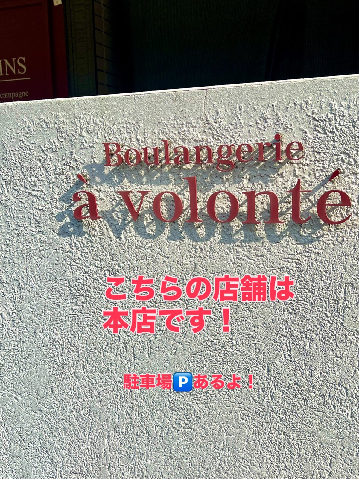 ア・ヴォロンテ本店の壁の赤いロゴ看板