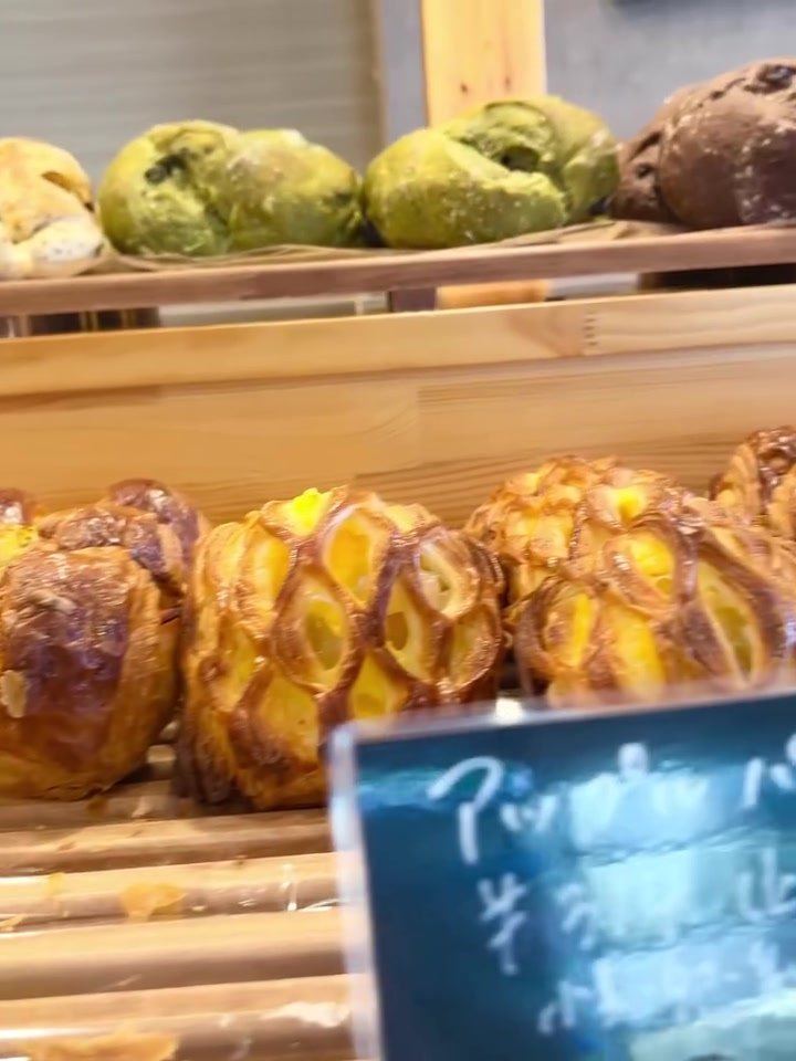 チョップアップクラスト アップルパイなどのデニッシュと抹茶色のパンの棚