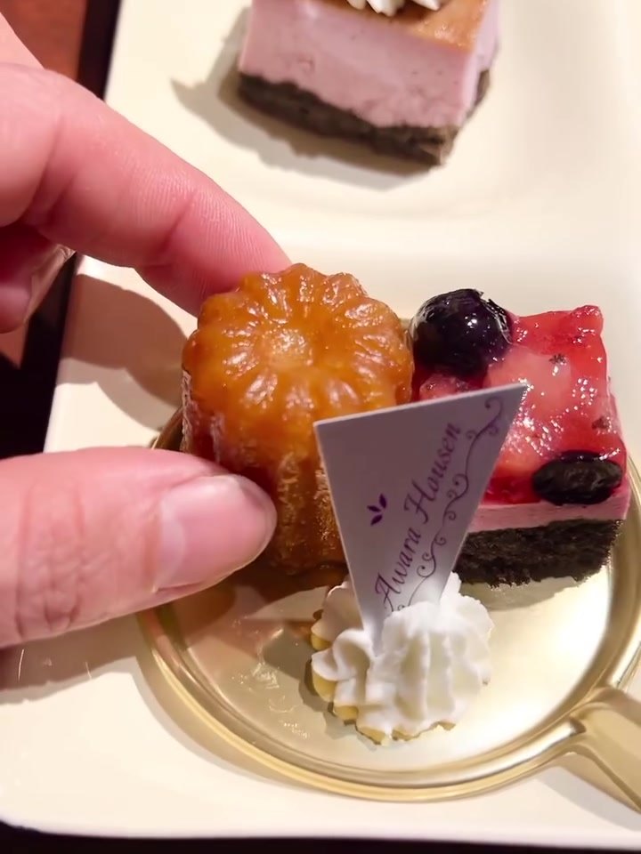 グランディア芳泉のブッフェのカヌレとケーキを手に持ったところ