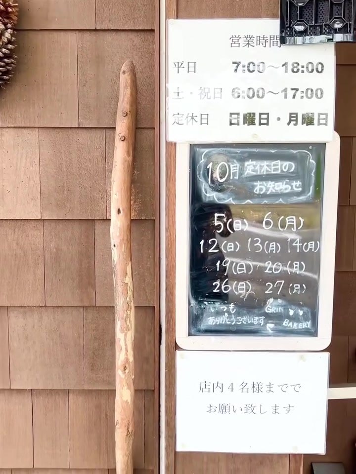 グリンベーカリー入口の営業時間と定休日の案内板
