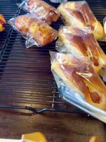 パンテス 網の上に並ぶ袋入りのねじりパン