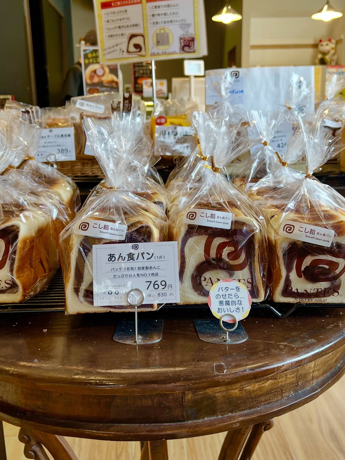 パンテス レジ前の丸テーブルに並ぶ袋入りのあん食パン