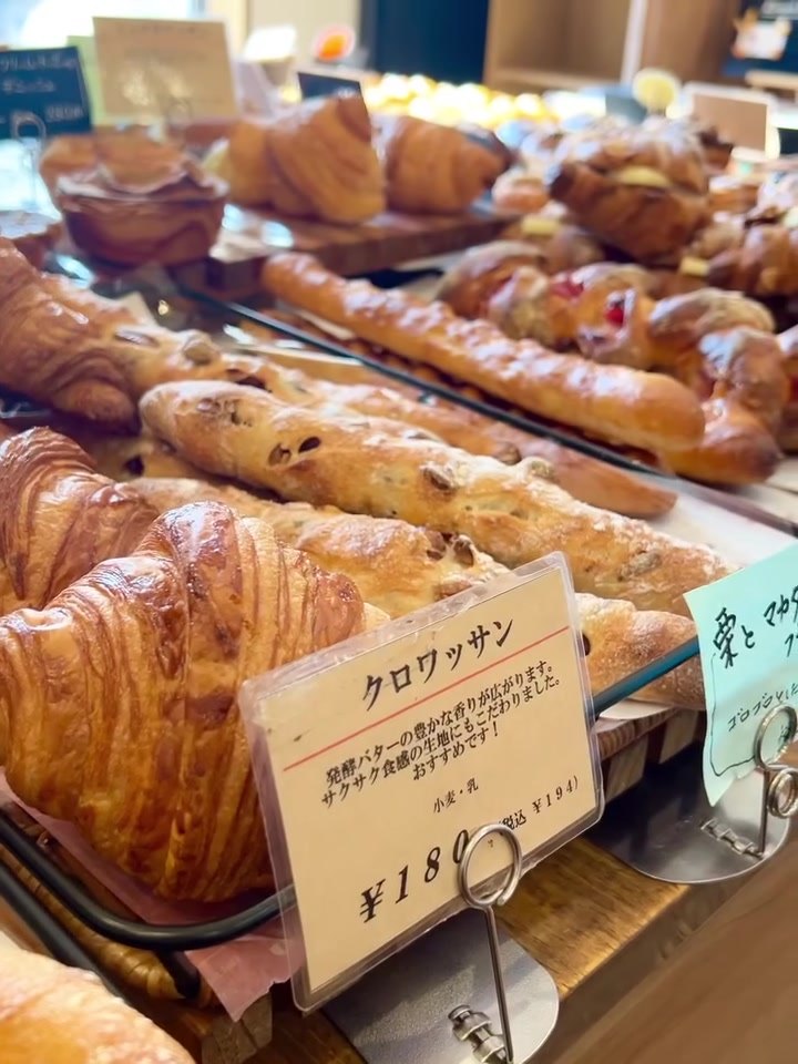 ブレッディア店内、クロワッサンなど焼きたてパンの陳列と値札