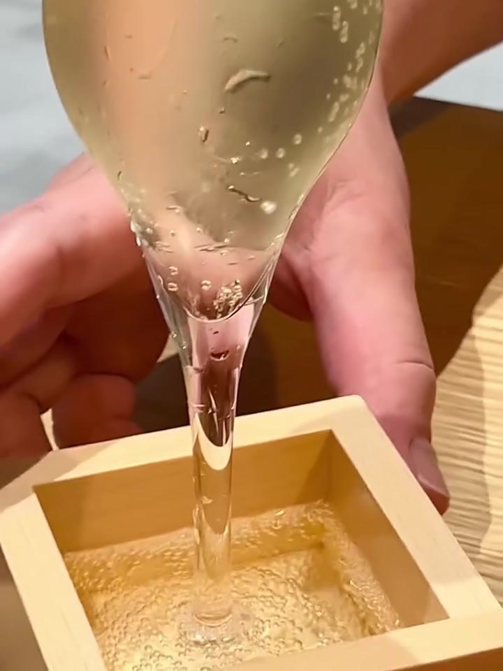 サケトアテ 升にあふれるほど日本酒を注ぐ様子