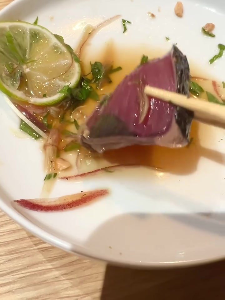 サケトアテ 柑橘を添えたたたきを箸で持ち上げる