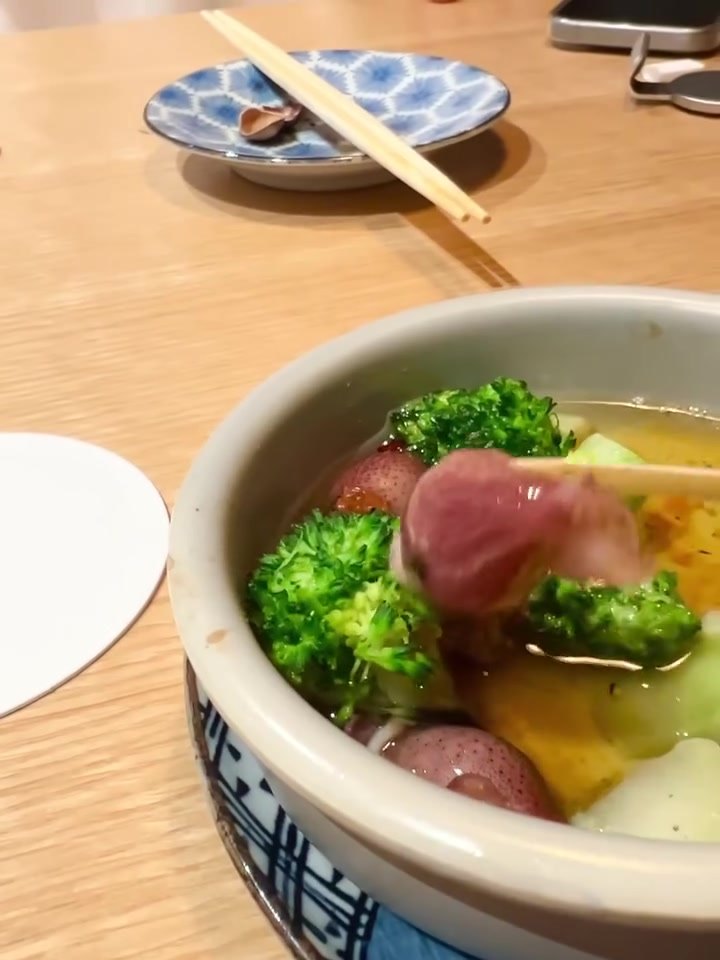 サケトアテ アヒージョの具を箸でつまむ様子